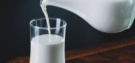 person pours milk into glass